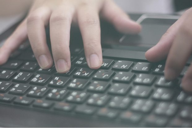 Hands typing on computer keyboard